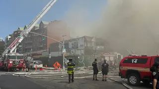 Nearly two dozen people injured as monster fire rips through wooden apartment block leaving resident trapped